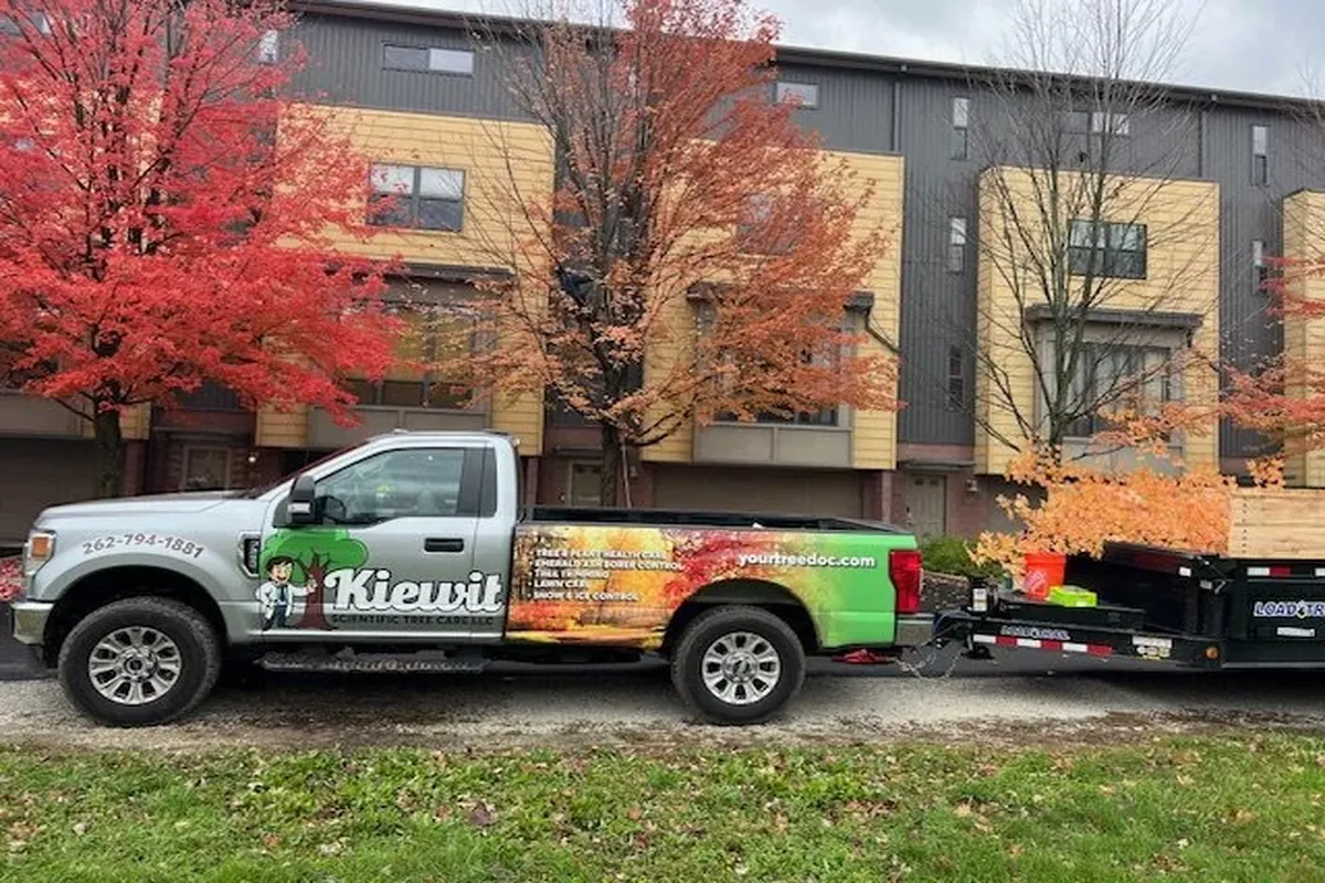 Kiewitt work truck hauling tree and equipment